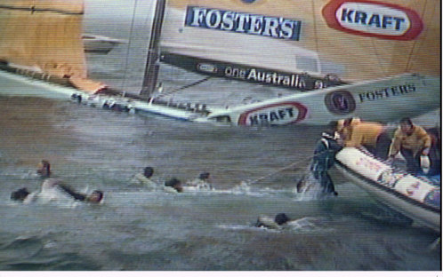 Crew members of the sinking oneAustralia are rescued as the cripped America's Cup racing boat, cracked in two at midships, sinks in the background in the worst accident in the history of the 1995 America's Cup, off San Diego.