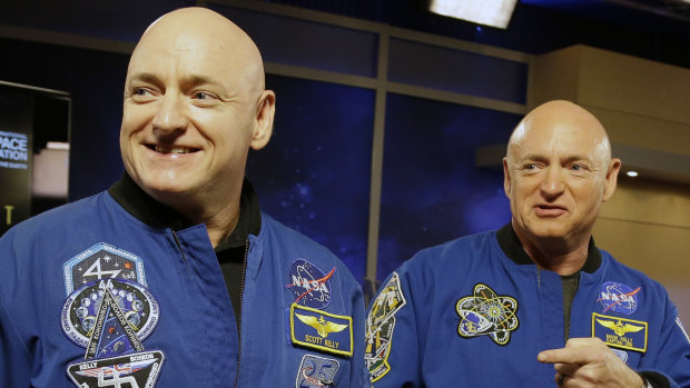 NASA astronaut Scott Kelly, left, and his identical twin, Mark, stand together before a news conference in Houston in 2014.