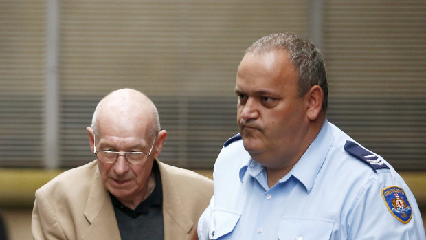 Roger Rogerson, left, is escorted out of Sydney's King Street courts in 2016.