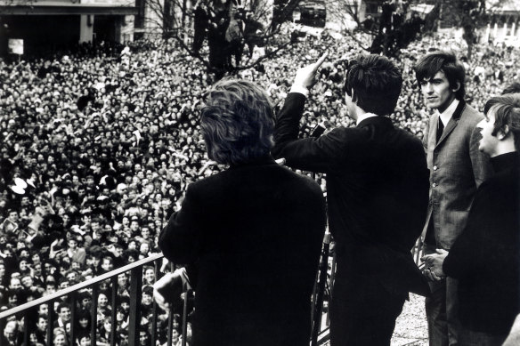 The Beatles wave to fans from the first floor balcony of the Southern Cross Hotel on their 1964 Australian tour.