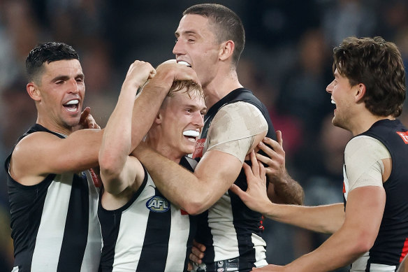 Collingwood’s Joe Richards, middle, is mobbed by his teammates after kicking his first AFL goal.
