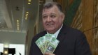 Member for Hughes Craig Kelly with fake trillion dollar notes to ‘commemorate Australia’s Net Government Debt’ on budget day at Parliament House in Canberra