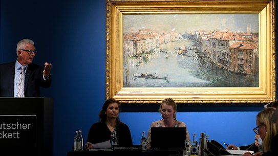Auctioneer Roger McIlroy with Arthur Streeton’s painting The Grand Canal, 1908, auctioned at Deutscher and Hackett in Melbourne.  