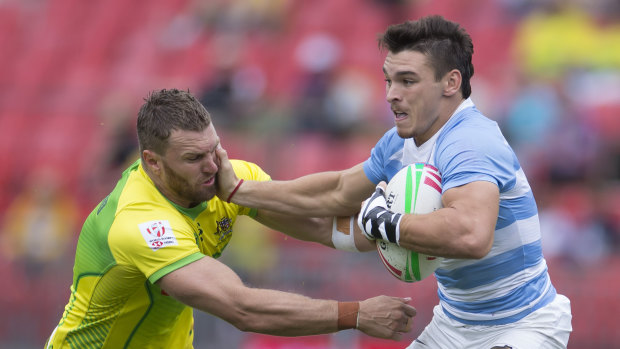 Argy bargy: Argentina's Jimmy Yobo palms off Lewis Holland at the Sydney Sevens. 