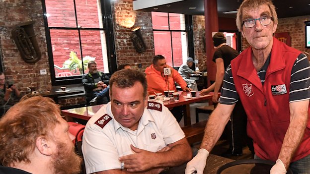 Salvation Army Major Brendan Nottle and Trevor Wulf check on a diner at Melbourne's Magpie Nest.