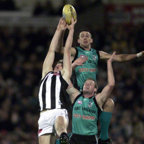 Jason Cloke competes in the air with Port’s Darren Mead and Josh Francou.