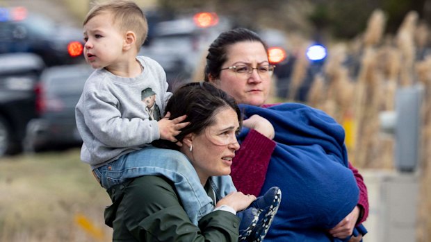 Families are escorted away from the scene of the attack at Temple Israel Synagogue in the US state of Michigan.