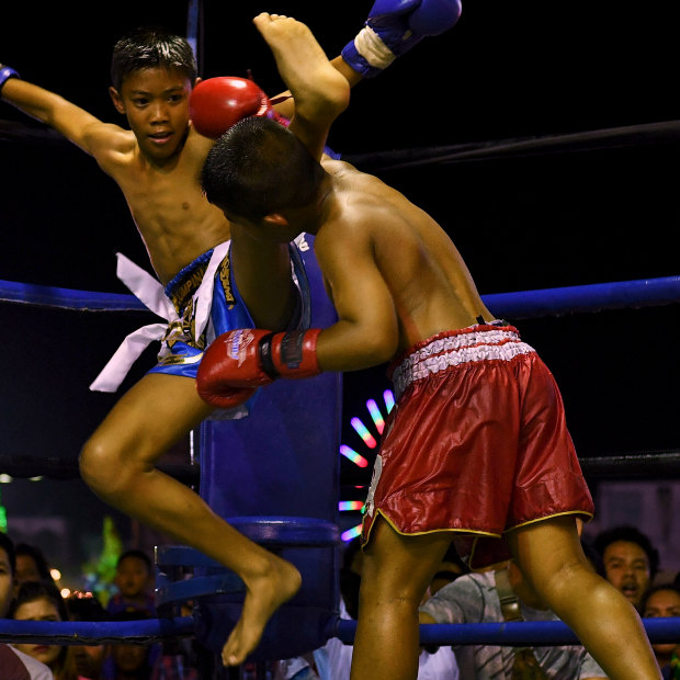 Mauy Thai fighter Samsun, 11 (right), is hit by his opponent during a Muay Thai fight that he won on Thursday night. The Muay Thai fight was a part of the Lop Buri’s Loi Krathong festival celebrations.