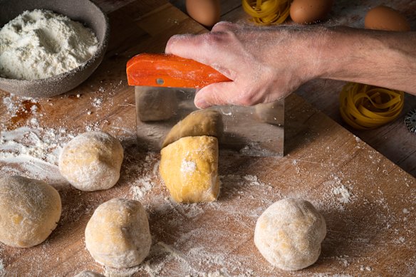 The wide, flat pastry scraper blade can be used to transfer chopped vegetables to the pot.