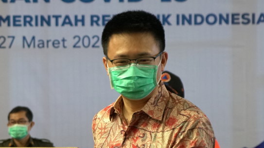 Chinese and Indonesian officials pose with aid supplied by China as it arrived in Jakarta.