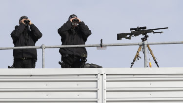 Police marksmen scan the area as they await the arrival of President Donald Trump and first lady Melania Trump at Stansted Airport in England.