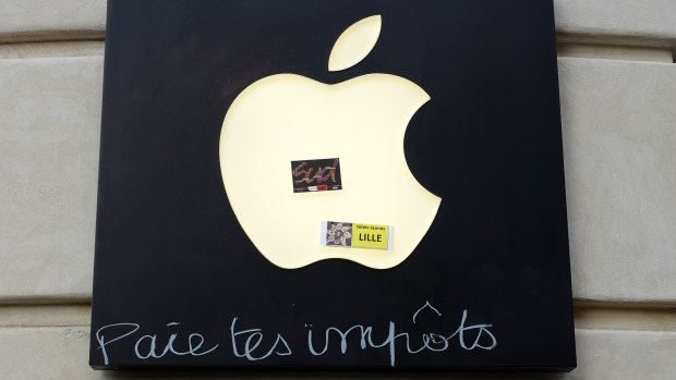 Graffiti written on an Apple sign reading "Pay your taxes", in front of an Apple store during a demonstration on Saturday in Lille, Northern France.