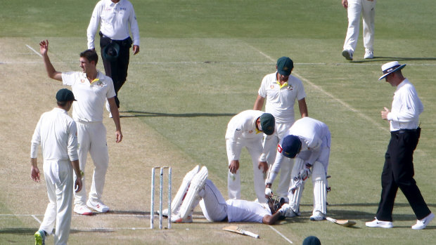 Distressing scene: Dimuth Karunaratne lies on the ground after being struck by a bouncer.