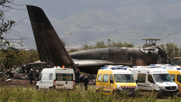 Firefighters and civil security officers work at the scene of a fatal military plane crash in Boufarik.