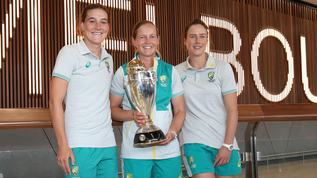 Annabel Sutherland, Meg Lanning and Ellyse Perry pose with the World Cup trophy after arriving home in Melbourne.