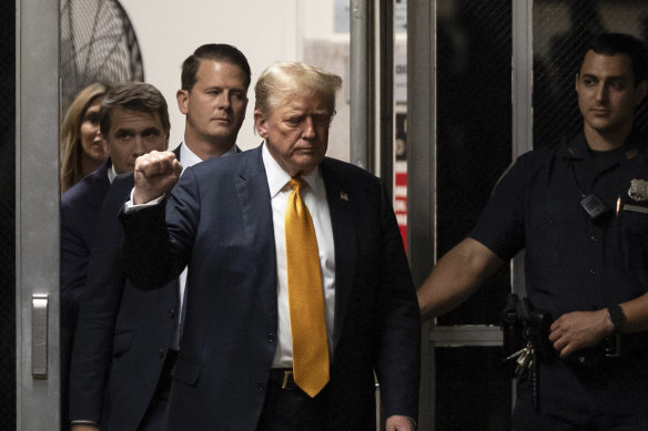 Former president Donald Trump gestures as he walks to the courtroom during his hush money trial at Manhattan criminal court.