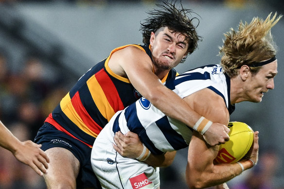 Tom Stewart of the Cats tackled by  Ned McHenry of the Crows.