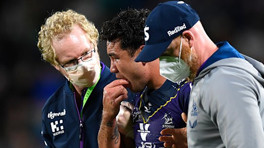 A groggy Jahrome Hughes is helped off Sunshine Coast Stadium after an illegal hit in 2021.