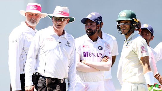 Tim Paine looks on as officials investigate a report of crowd abuse at the SCG on Sunday.