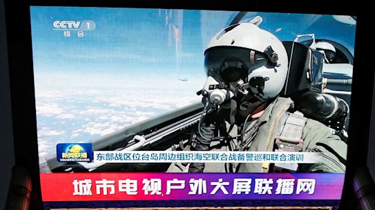 A screen in a Beijing shopping area broadcasts footage of the military drills in the Taiwan Strait.