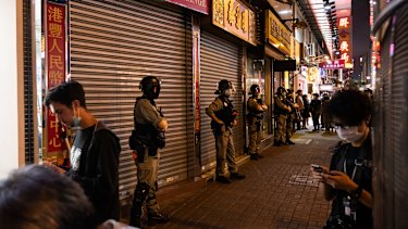 Riot police stand guard at the entrance to Prince Edward MTR underground train station on Sunday.