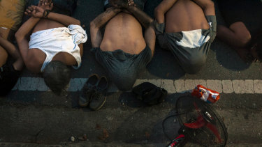 People lie on the ground after being detained for allegedly looting a supermarket during a continued power outage in Santa Cruz del Este, Caracas, Venezuela.