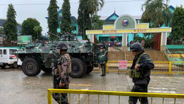Soldiers walk near an armoured personnel carrier parked outside the Saguiaran city hall in Lanao del Sur province, southern Philippines, during the  referendum on a new autonomous region.