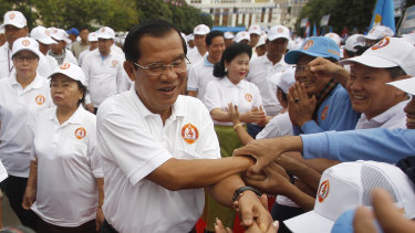 Cambodian Prime Minister Hun Sen, centre, greets supporters.