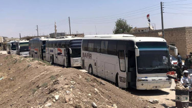 Buses arrive in Tel el-Eis, the crossing between Aleppo and Idlib provinces, as some 7000 people were evacuated from villages run by rebels in July.