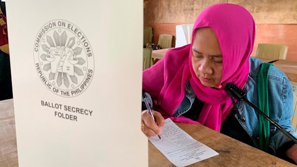 A Muslim woman votes in a referendum at the Marawi Sagonsongan elementary school polling station in Marawi.