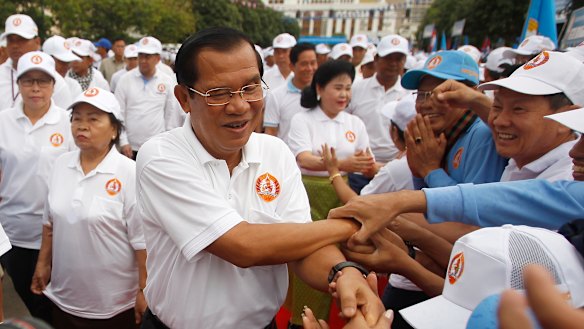 Cambodian Prime Minister Hun Sen, centre, greets supporters on arrival for his Cambodian People's Party's campaign in Phnom Penh.