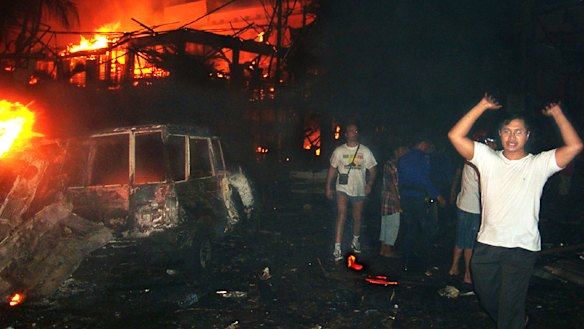 Residents and tourists evacuate the scene of the 2002 bomb blast in Bali, Indonesia. The attack killed 202 people including 88 Australians.