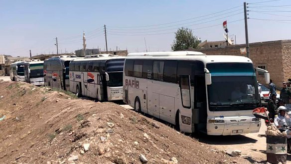 Buses arrive in Tel el-Eis, the crossing between Aleppo and Idlib provinces, as some 7000 people were evacuated from villages run by rebels in July.
