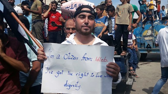A man holds a placard in Harim, in Idlib province, on Friday as part of a day of protests against Syrian President Bashar al-Assad and his troops' imminent offensive against Idlib.