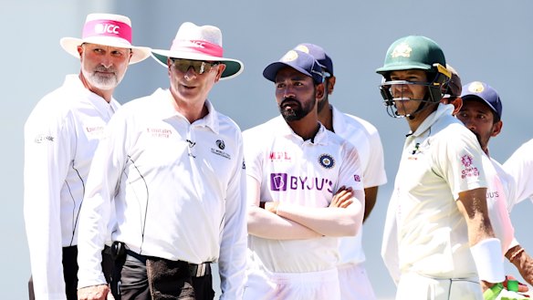Tim Paine looks on as officials investigate a report of crowd abuse at the SCG on Sunday.