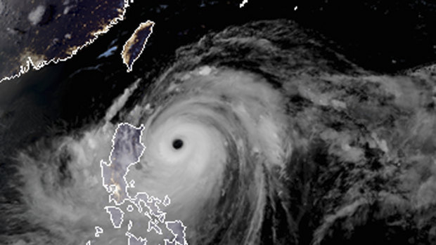 A satellite image with land graphic borders shows the width and trajectory of Typhoon Mangkhut as it approached the Philippines.