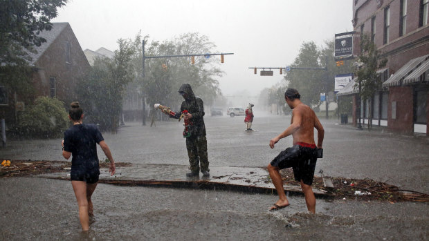 People survey the damage on Front Street in downtown New Bern, North Carolina.