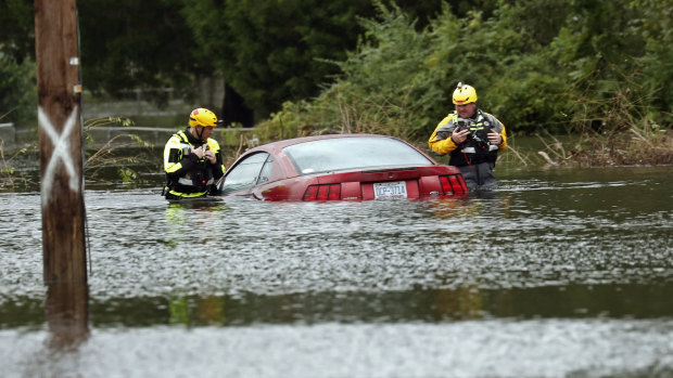 Members of a swift water rescue team check a submerged vehicle stranded by floodwaters caused by the tropical storm Florence in New Bern, North Carolina, on Saturday.