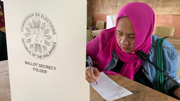 A Muslim woman votes in a referendum at the Marawi Sagonsongan elementary school polling station in Marawi.
