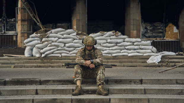 A Ukrainian soldier takes a rest on the steps of the City Hall in Izyum, in the Kharkiv region recaptured by Ukraine.