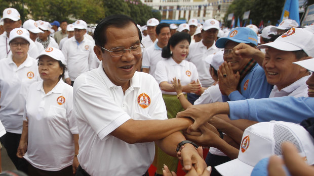 Cambodian Prime Minister Hun Sen, centre, greets supporters on arrival for his Cambodian People's Party's campaign in Phnom Penh.