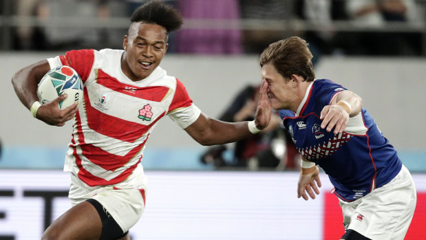 Japan's Kotaro Matsushima, left, fends off Russia's Vladislav Sozonov to score his third try.