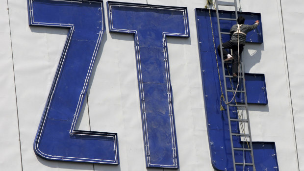 A worker installs the logo of ZTE, a Chinese communications company in Nanjing, China.
