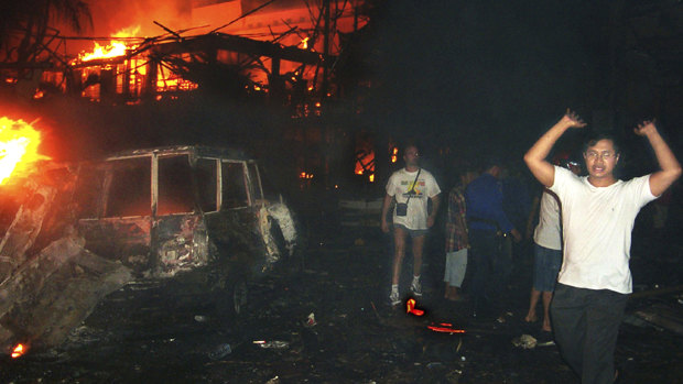 Residents and tourists evacuate the scene of the 2002 bomb blast in Bali, Indonesia. The attack killed 202 people including 88 Australians.