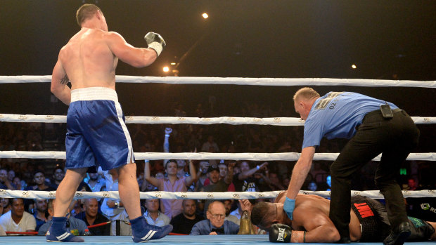 Down and out: The referee attends to John Hopoate while Paul Gallen looks on.