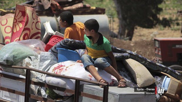 Children with their family belongings in the back of a truck fleeing from Daraa, southern Syria. 
