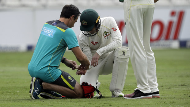 Man down: Tim Paine receives treatment after being hit on his right thumb, an incident that exposed Australia's leadership vacuum. 