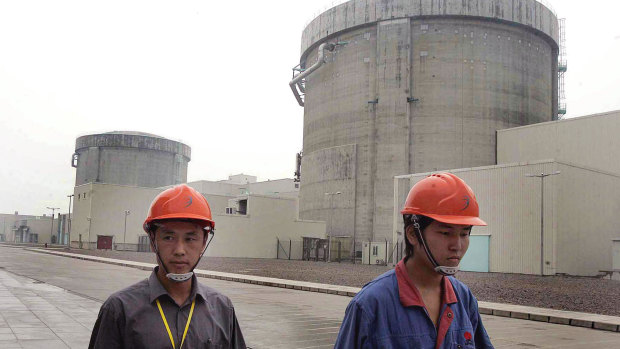 Workers walk past Qinshan No. 2 Nuclear Power Plant, China's first self-designed and self-built national commercial nuclear power plant in 2005.