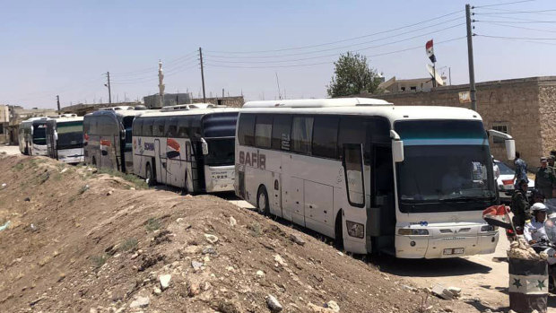 Buses arrive in Tel el-Eis, the crossing between Aleppo and Idlib provinces, as some 7000 people were evacuated from villages run by rebels in July.