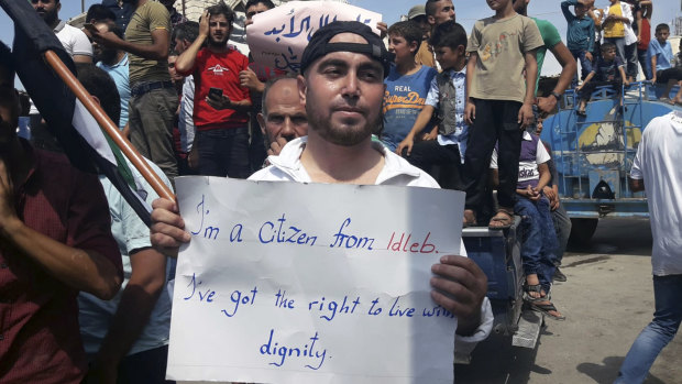 A man holds a placard in Harim, in Idlib province, on Friday as part of a day of protests against Syrian President Bashar al-Assad and his troops' imminent offensive against Idlib.